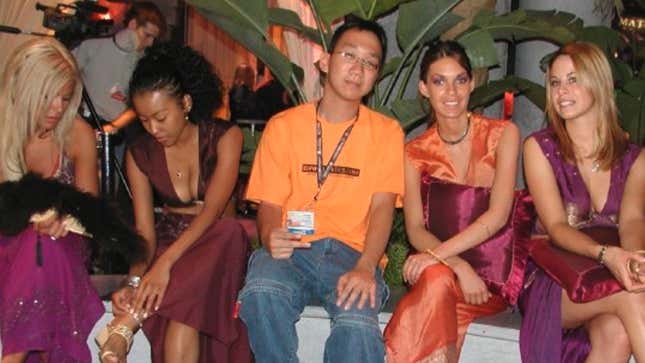 Journalist Gene Park sits in between several women dressed in orange and purple outfits. 