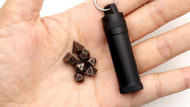An image shows someone holding tiny metal dice. 